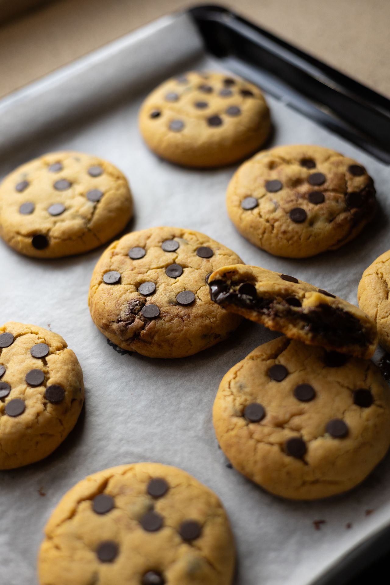 One bowl chocolate chip cookies fresh from the oven on a baking tray, soft and chewy with melty chocolate chips