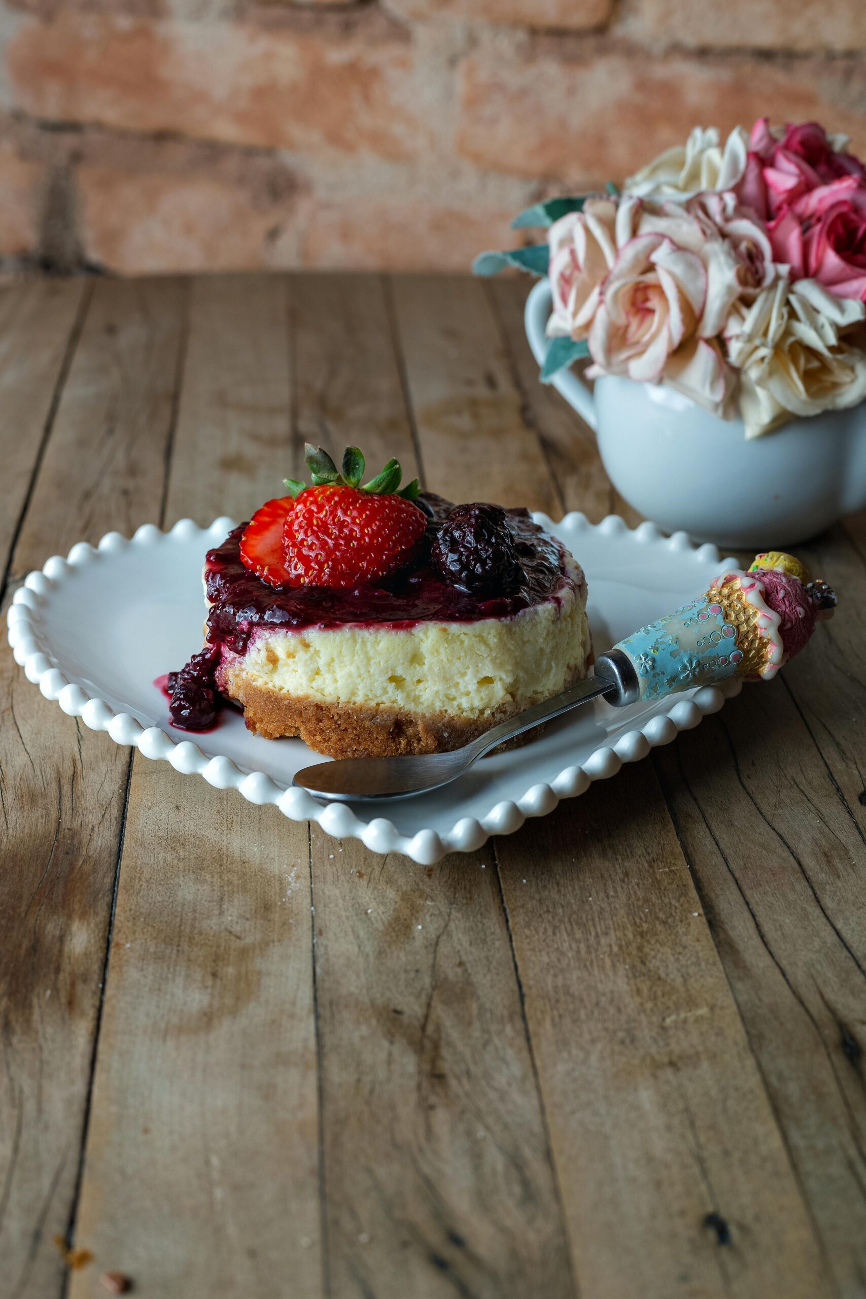 Mini Cheesecake Recipe topped with berry compote and a fresh strawberry...