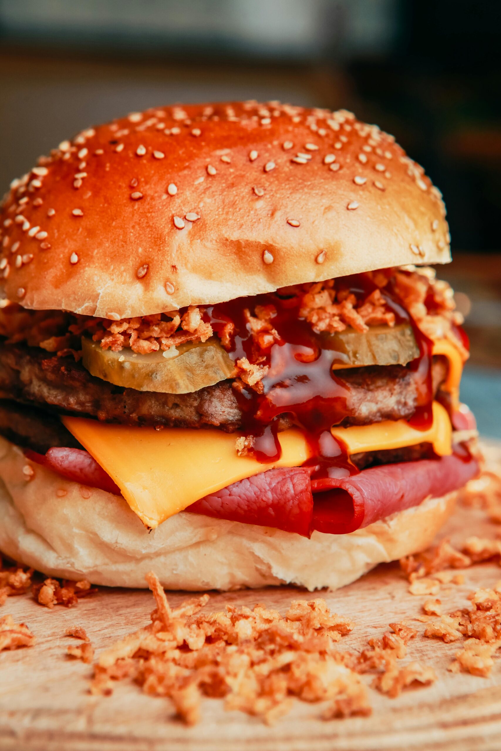 Ground venison burger recipe with melted cheese, pickles, and crispy fried onions on a sesame bun