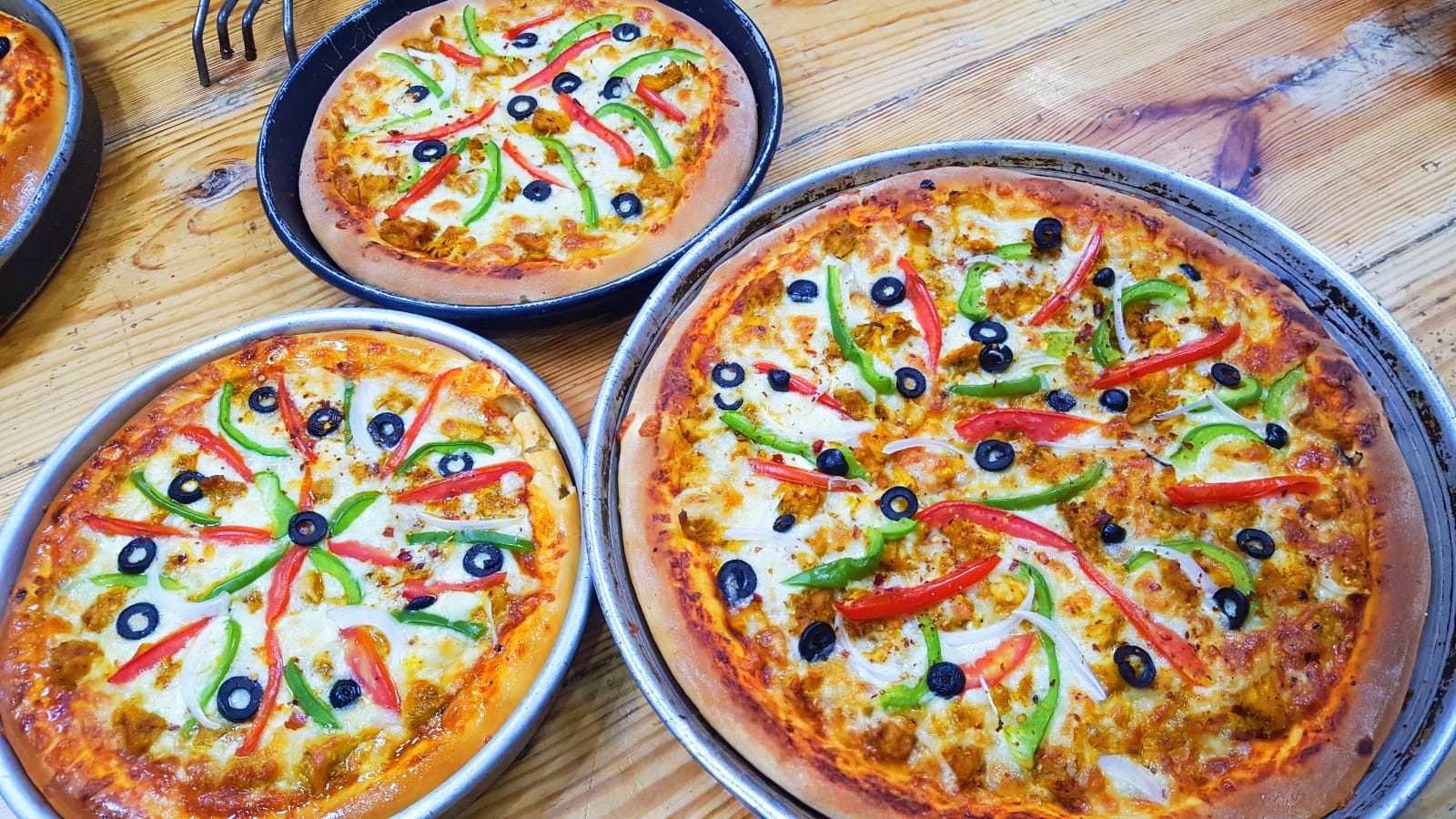 Easy homemade pizza dough with colorful vegetable toppings baked to golden perfection on round pans