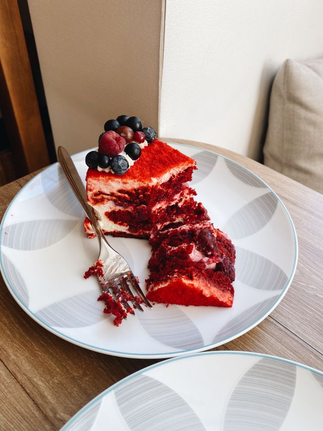 Red velvet cake recipe slice served on a plate with fresh berries and a fork