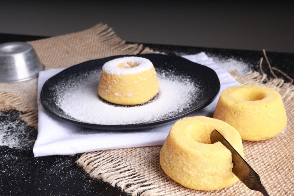 3 ingredient condensed milk cake dusted with powdered sugar served on a dark plate
