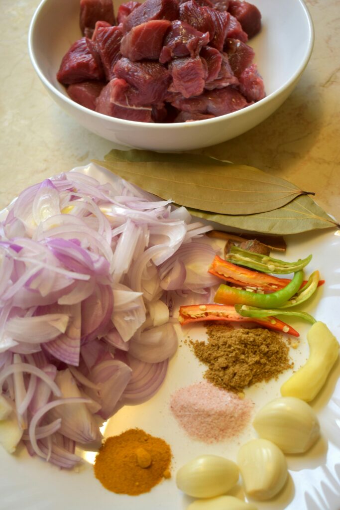 Raw ingredients for healthy Eid recipes with minimal spices including sliced onions, green chilies, and ginger