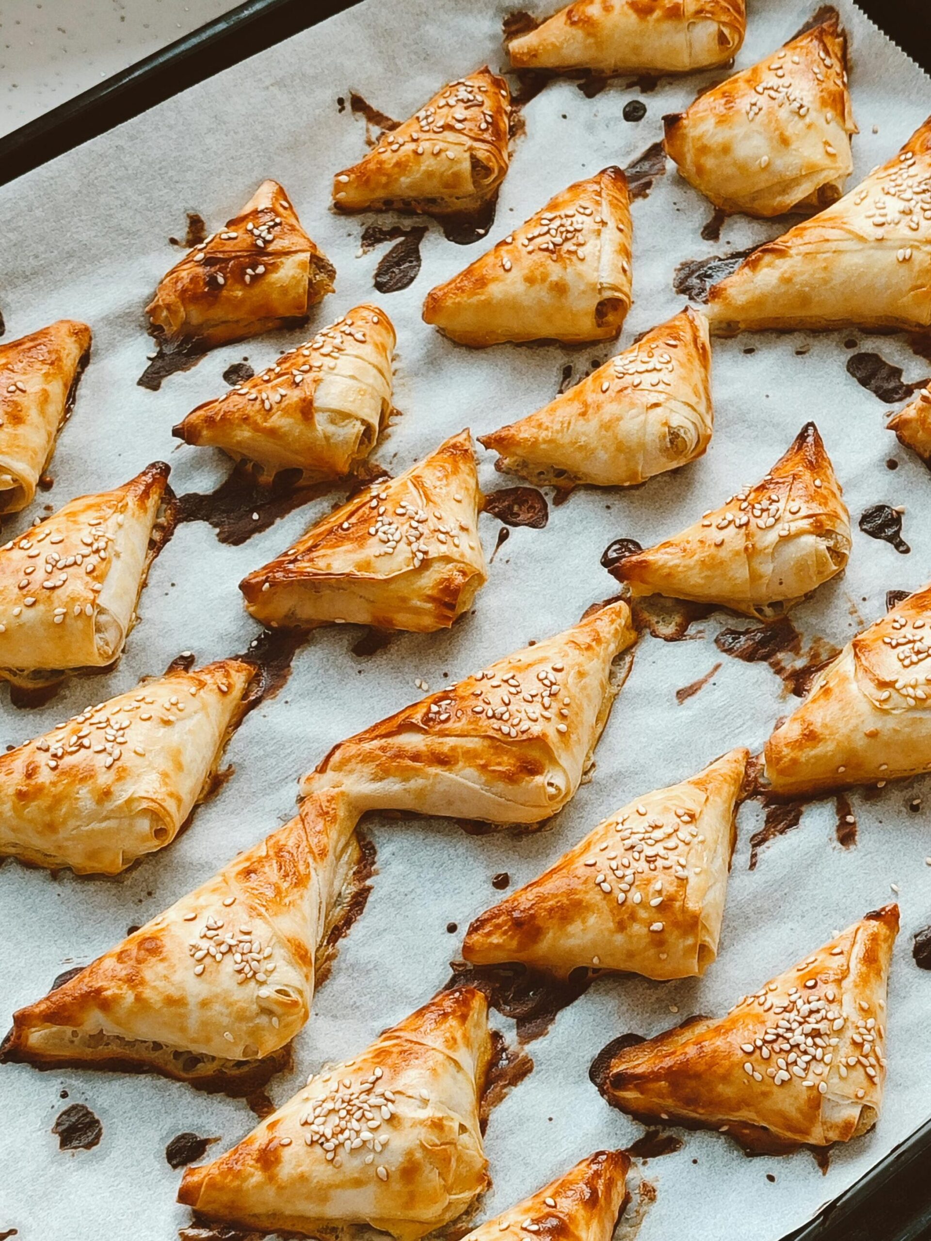 Baked Chicken Pastries baked on a sheet tray as crispy triangle bakery style chicken patties