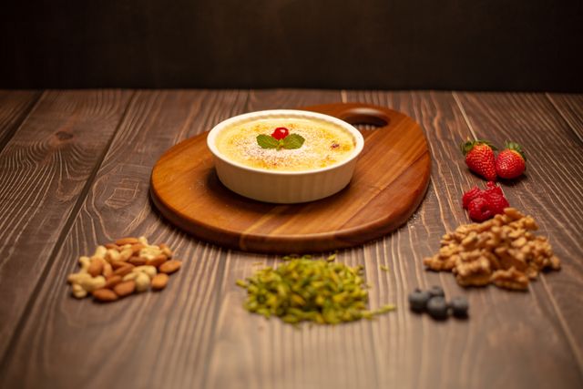 alt="Quick Sheer Khurma Recipe served in a white bowl on a wooden board, garnished with nuts, pistachios, and fresh mint – a creamy Eid dessert made with vermicelli and condensed milk"