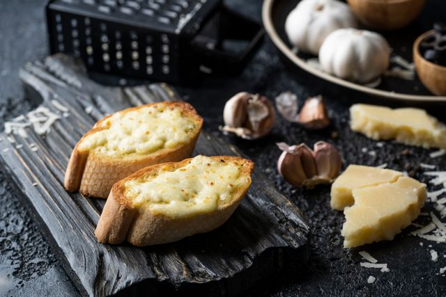 Toasted easy sourdough garlic bread slice with fresh garlic cloves on the side