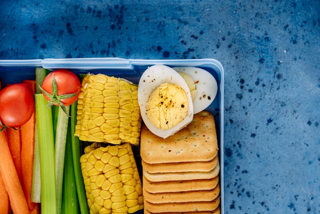 Easy lunchbox snacks for kids packed with corn, boiled egg, and fresh vegetables