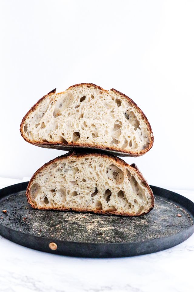 Sliced cardamom sourdough bread showing open airy crumb on a white plate