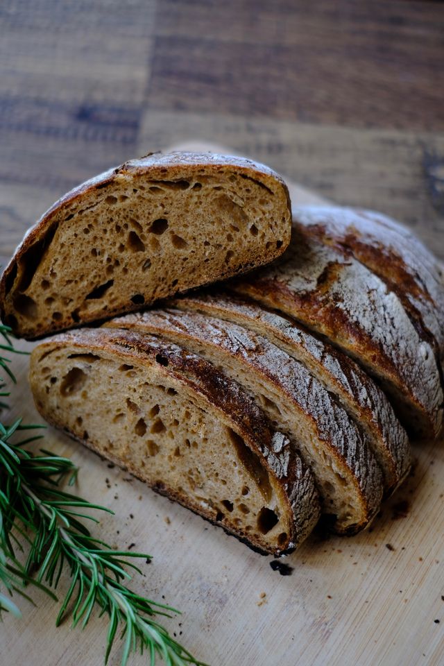 Sliced crusty loaf of easy sourdough garlic bread with a dark golden crust