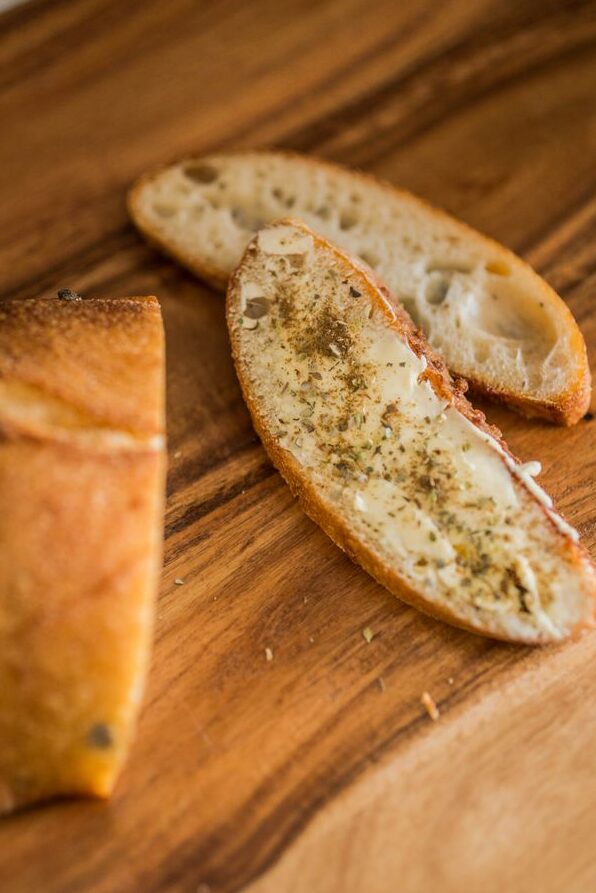 Sliced easy sourdough garlic bread pieces arranged on a wooden board